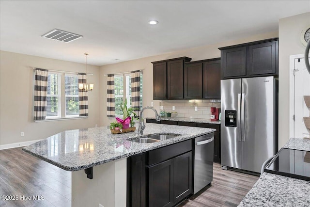 145 Cabin Branch Dr, Carthage, NC 28327 - kitchen featuring stainless steel appliances, a sink, light wood-type flooring, a chandelier, and light stone counters