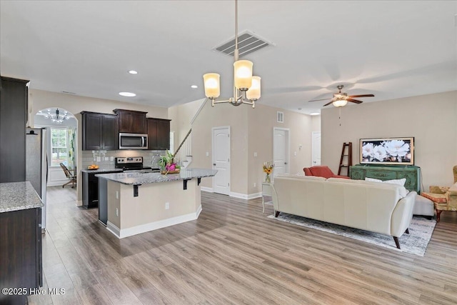 145 Cabin Branch Dr, Carthage, NC 28327 - kitchen featuring appliances with stainless steel finishes, open floor plan, light wood-style flooring, a ceiling fan, and a chandelier
