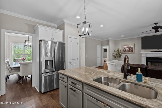 125 Steeplechase Way, Southern Pines, NC 28387 - kitchen with stainless steel fridge, a sink, open floor plan, a chandelier, and light stone countertops