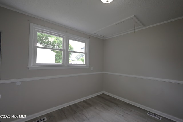 420 New River Dr, Jacksonville, NC 28540 - spare room featuring attic access, wood finished floors, a textured ceiling, and baseboards