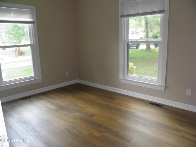 unfurnished room featuring baseboards and wood finished floors
