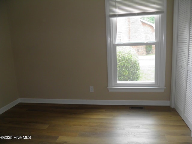 empty room with plenty of natural light and wood finished floors