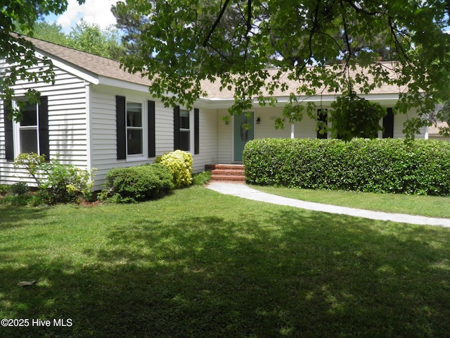 ranch-style home featuring a front yard and roof with shingles