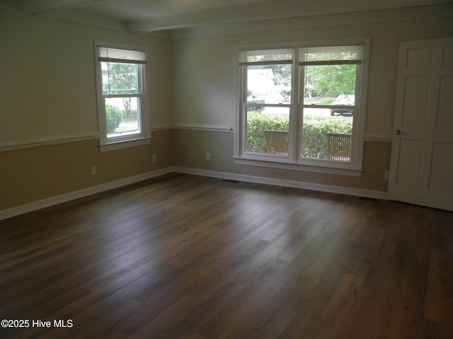 unfurnished room with dark wood-type flooring, baseboards, and beamed ceiling
