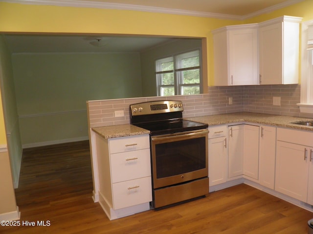 kitchen featuring stainless steel range with electric cooktop, white cabinets, crown molding, decorative backsplash, and light wood-style flooring
