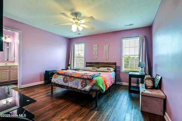 229 Red Carnation Dr, Holly Ridge, NC 28445 - bedroom with wood finished floors, a textured ceiling, baseboards, and ensuite bathroom