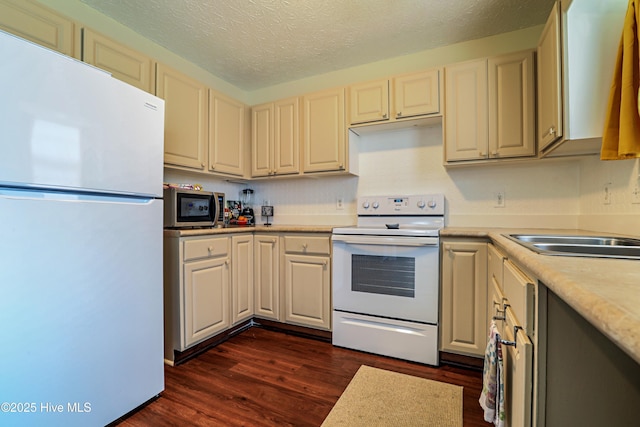 229 Red Carnation Dr, Holly Ridge, NC 28445 - kitchen featuring white appliances, light countertops, dark wood-type flooring, a textured ceiling, and a sink