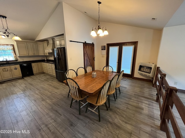 2483 Mcneill Hobbs Rd, Bunnlevel, NC 28323 - dining area featuring a chandelier, a barn door, heating unit, wood finished floors, and high vaulted ceiling