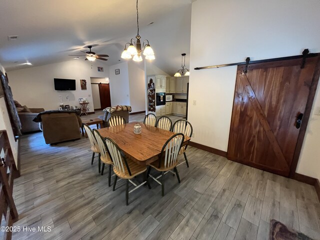 2483 Mcneill Hobbs Rd, Bunnlevel, NC 28323 - dining room with lofted ceiling, a ceiling fan, light wood-style flooring, baseboards, and a barn door