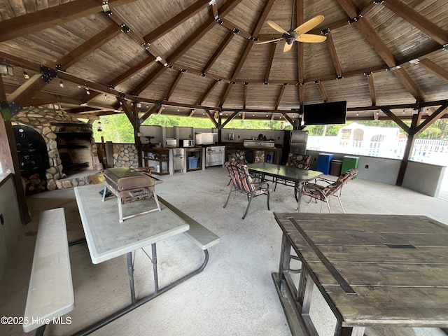 2483 Mcneill Hobbs Rd, Bunnlevel, NC 28323 - view of patio with an outdoor kitchen, a gazebo, a ceiling fan, and an outdoor stone fireplace