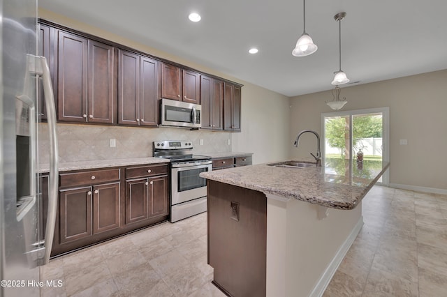 1232 Teakwood Dr, Greenville, NC 27834 - kitchen featuring appliances with stainless steel finishes, a sink, decorative backsplash, dark brown cabinetry, and baseboards