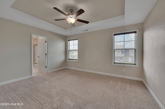 1232 Teakwood Dr, Greenville, NC 27834 - spare room with a tray ceiling, a ceiling fan, light colored carpet, and baseboards