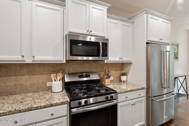 270 Wembley Dr, Clayton, NC 27527 - kitchen featuring appliances with stainless steel finishes, white cabinetry, light stone counters, and decorative backsplash