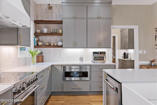 6920 Runningbrook Ter, Wilmington, NC 28411 - kitchen featuring gray cabinetry, stainless steel appliances, range hood, backsplash, and crown molding