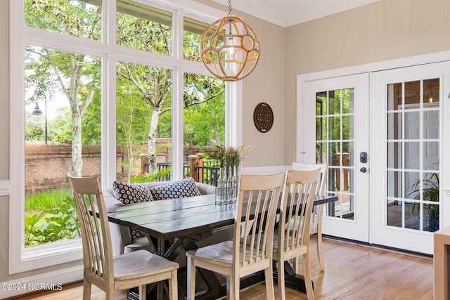6920 Runningbrook Ter, Wilmington, NC 28411 - dining space featuring a chandelier, french doors, light wood-style flooring, and crown molding