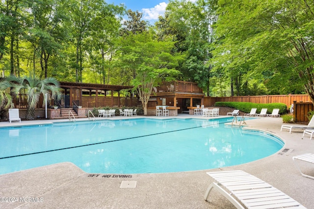 6920 Runningbrook Ter, Wilmington, NC 28411 - community pool featuring a patio, fence, and view of scattered trees