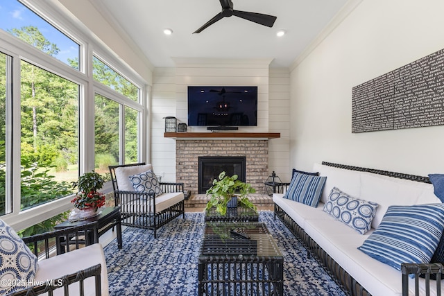 sunroom / solarium featuring ceiling fan and an outdoor living space with a fireplace