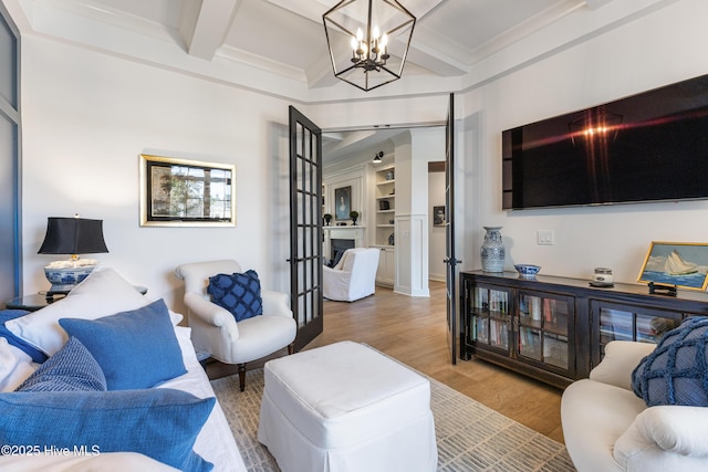 living room featuring coffered ceiling, wood finished floors, a chandelier, beam ceiling, and crown molding