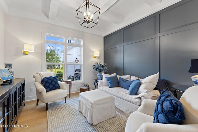 living room with a chandelier, coffered ceiling, light wood-style floors, beam ceiling, and baseboards