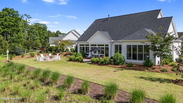 back of house with a patio area, roof with shingles, a lawn, and board and batten siding