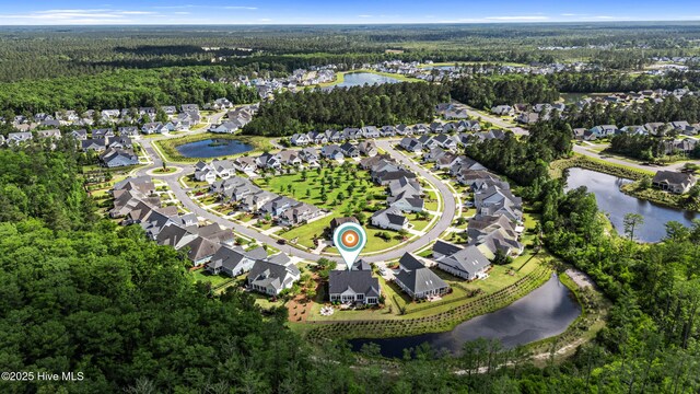 aerial overview of property's location with a forest, nearby suburban area, and a nearby body of water