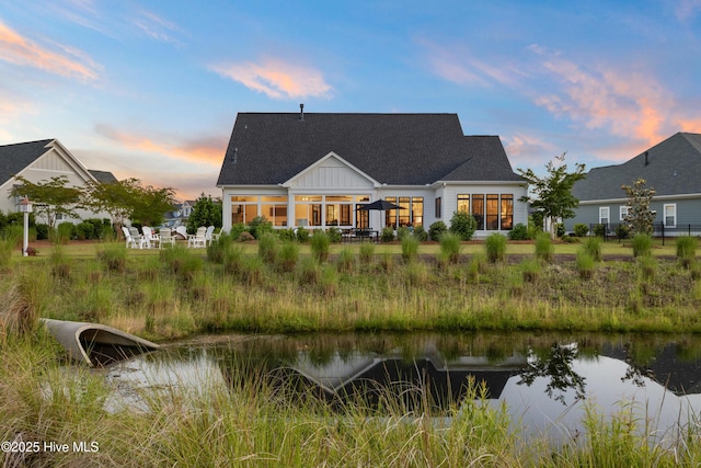 back of house at dusk with a water view