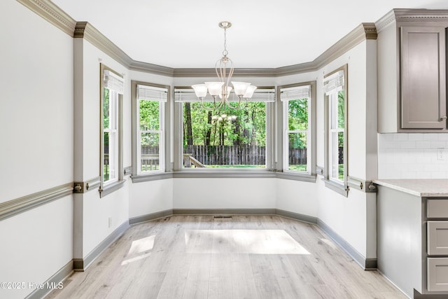 103 E Raintree Ln, Goldsboro, NC 27534 - unfurnished dining area featuring healthy amount of natural light, light wood-style flooring, a chandelier, and crown molding