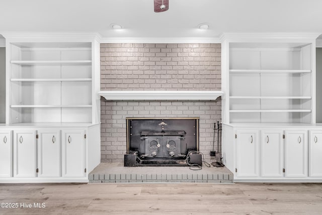 103 E Raintree Ln, Goldsboro, NC 27534 - unfurnished living room with a brick fireplace, light wood-style floors, ornamental molding, and built in shelves