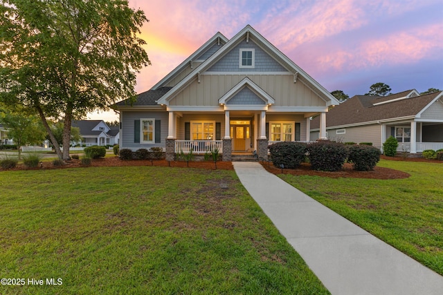 craftsman house featuring board and batten siding, a porch, and a lawn