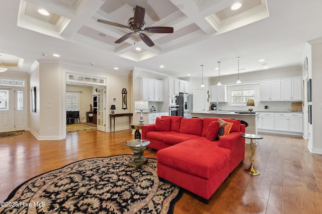 living area with crown molding, light wood-style floors, ceiling fan, coffered ceiling, and beamed ceiling