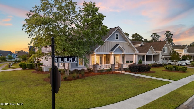 craftsman house with board and batten siding, a porch, and a front yard