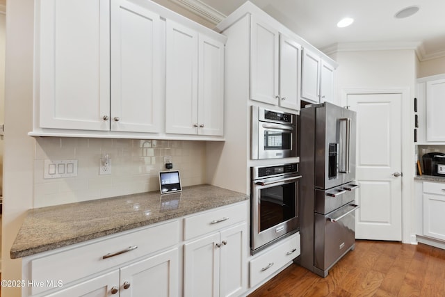 kitchen with high end fridge, ornamental molding, white cabinets, and backsplash