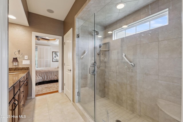 ensuite bathroom with a shower stall, tile patterned floors, vanity, and ceiling fan