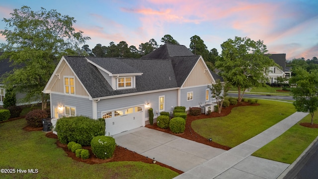 view of front of home featuring concrete driveway, a yard, board and batten siding, and roof with shingles