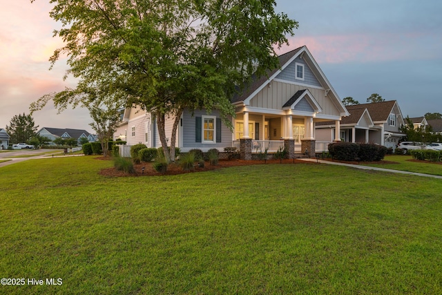 craftsman inspired home with covered porch, board and batten siding, and a front lawn