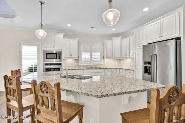 kitchen with stainless steel appliances, a sink, backsplash, ornamental molding, and white cabinets