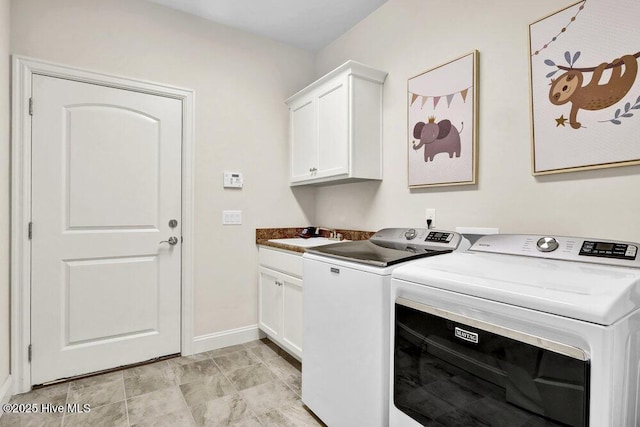 laundry area featuring cabinet space, washing machine and clothes dryer, and baseboards
