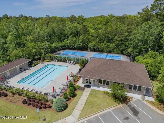 view of subject property featuring a forest and a pool area