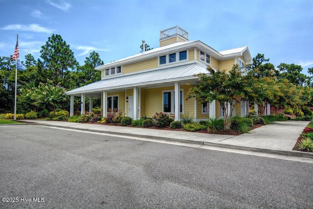 country-style home featuring metal roof and a porch