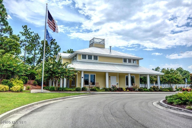 farmhouse inspired home with a porch and metal roof