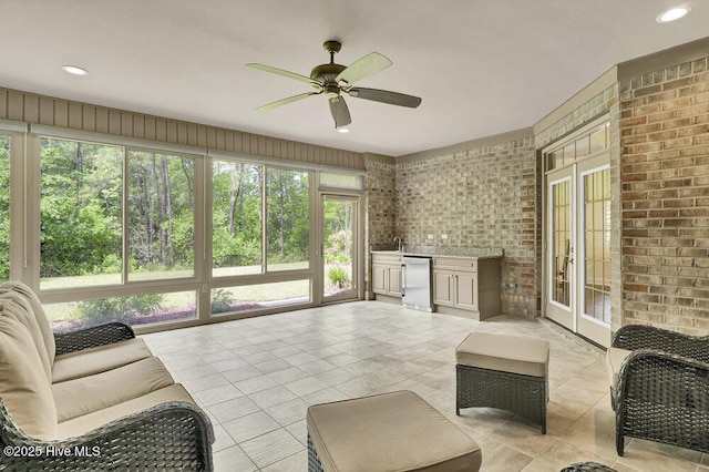 sunroom featuring tile patterned flooring, french doors, brick wall, bar area, and recessed lighting