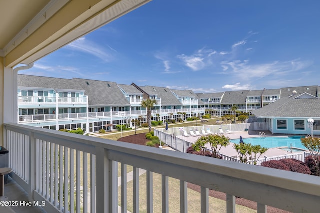 balcony with a residential view and view of pool