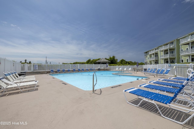 community pool featuring fence and a patio