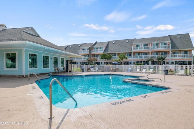 community pool featuring a patio, fence, and a community hot tub
