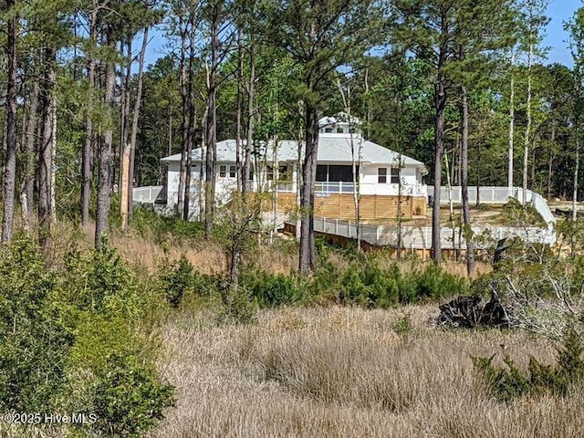 view of yard with a wooded view and fence