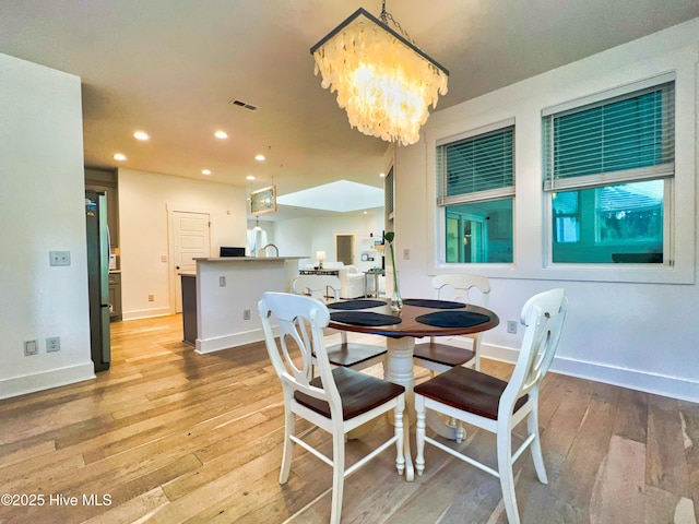 dining area with light wood finished floors, a chandelier, recessed lighting, and baseboards