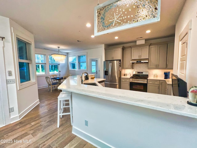 kitchen with appliances with stainless steel finishes, a sink, recessed lighting, gray cabinetry, and under cabinet range hood
