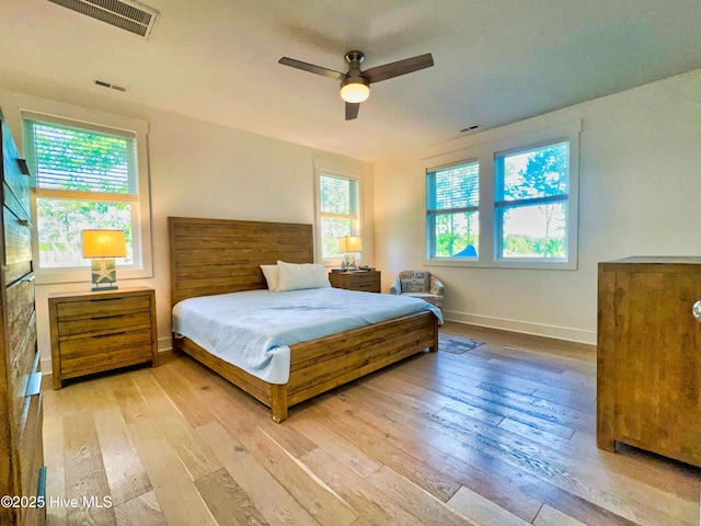 bedroom with light wood-type flooring, baseboards, and ceiling fan