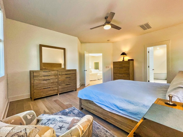 bedroom with wood finished floors, baseboards, ceiling fan, and ensuite bathroom