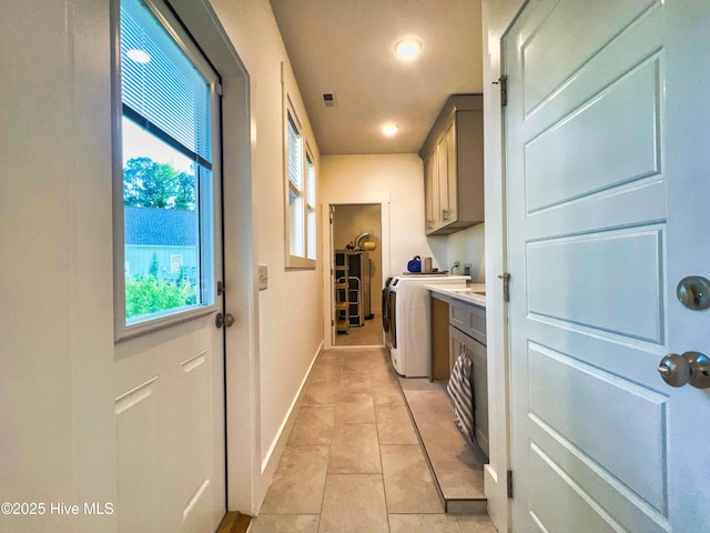 washroom featuring cabinet space, washer / dryer, recessed lighting, light tile patterned floors, and baseboards